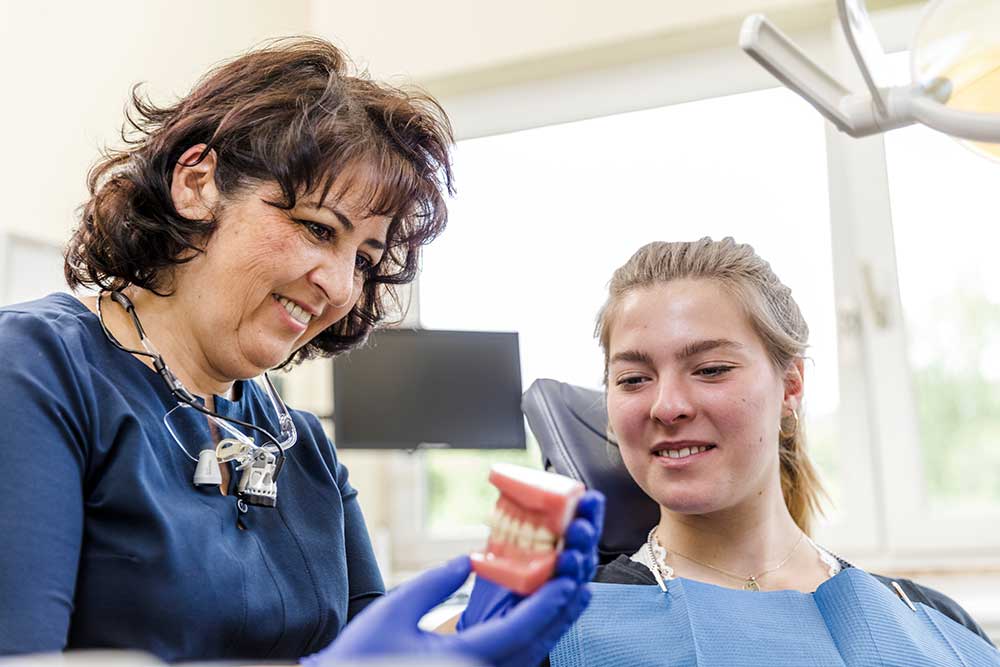 Zahnarzt Windeck - Hamood - Leistungen - Ästhetische Zahnheilkunde - Zahnärztin mit Patientin auf Behandlungsstuhl